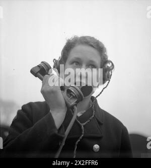 GIRL GUNNERS : THE WORK OF THE AUXILIAIRE TERRITORIAL SERVICE IN A EXPERIMENTAL STATION, SHOEBURYNESS, ESSEX, ENGLAND, 1943 - lors d'un essai de tir d'obus par la Royal Artillery à Shoeburyness, Joyce Shannon, 20 ans soldat ATS téléphone à un poste d'observation pour leur dire quand l'arme est tirée, pour qu'ils puissent chercher l'éclatement de la coquille. Selon la légende originale, certains postes d'observation peuvent être jusqu'à 13 ou 14 miles de distance. Les obus sont tirés dans la mer à marée haute Banque D'Images