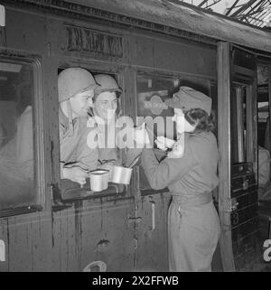 Un volontaire de la Croix-Rouge américaine sert du café aux militaires américains nouvellement arrivés à bord d'un train en Grande-Bretagne entre 1942 et 1945. Banque D'Images