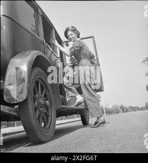 NOURRITURE POUR COCHONS : LE SERVICE VOLONTAIRE DES FEMMES COLLECTE LES DÉCHETS DE CUISINE RÉCUPÉRÉS, EAST BARNET, HERTFORDSHIRE, ANGLETERRE, 1943 - Mme Gerald de Rivaz du WVS monte dans la voiture de collecte de nourriture pour cochons qu'elle conduit à East Barnet, au début d'une journée de travail chargée pour ramasser les déchets de cuisine récupérés Banque D'Images