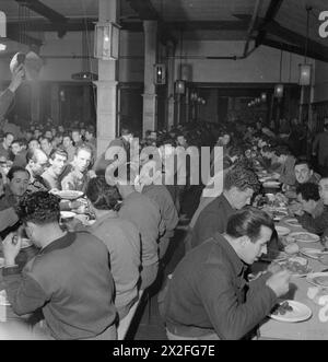 PRISONNIERS DE GUERRE ITALIENS EN GRANDE-BRETAGNE : LA VIE QUOTIDIENNE DANS UN CAMP de prisonniers de GUERRE ITALIENS, ANGLETERRE, Royaume-Uni, 1945 - Une vue générale des hommes mangeant dans le réfectoire du camp de travailleurs italiens N.144 près de Londres. Selon la légende originale 'au camp il y a un seul réfectoire dans lequel les 2000 collaborateurs mangent dans deux relais. Ici, ils mangent leur petit déjeuner le matin, avant d'aller travailler, et le repas du soir. À midi, les escadrons ouvriers emportent la nourriture crue avec eux et la préparent sur le lieu de travail. » Banque D'Images