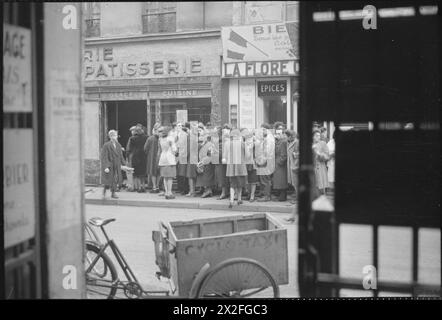 PARIS, PRINTEMPS 1945 : LA VIE QUOTIDIENNE À PARIS LIBÉRÉ, FRANCE, 1945 - Un grand groupe de civils fait la queue devant une boulangerie-pâtisserie dans une rue, quelque part à Paris. Il y a un grand nombre d'hommes dans cette file d'attente, ce qui est une grande différence par rapport aux files d'attente similaires en Grande-Bretagne. Un garçon vient d'acheter ses deux pains de baguette. Au premier plan peut être vu un 'Cyclo-Taxi' Banque D'Images