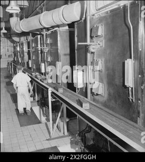 UNE BOULANGERIE MODERNE : LE TRAVAIL DE WONDER BAKERY, WOOD GREEN, LONDRES, ANGLETERRE, ROYAUME-UNI, 1944 - Un ouvrier vérifie les fours de la boulangerie Wonder, Wood Green. Selon la légende d'origine, il s'agit du « côté four de l'un des 4 fours à plaques mobiles alimentés au gaz » Banque D'Images