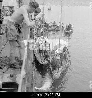 LA RÉOCCUPATION BRITANNIQUE DE HONG KONG, 1945 - les sampans chinois viennent aux côtés du débarquement du LST 304 à l'entrée du port de Hong Kong. Le LST 304 navigue dans le cadre du premier convoi à destination de Hong Kong après la reddition japonaise Banque D'Images