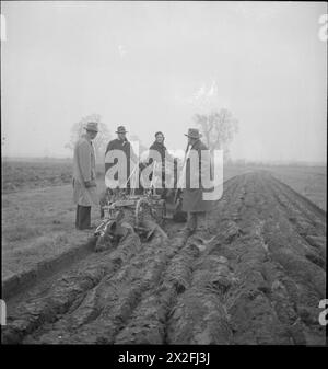 LES AGRICULTEURS AMÉRICAINS VISITENT LA GRANDE-BRETAGNE : LEND-LEASE EQUIPMENT IN ACTION, Royaume-Uni, 1943 - 18 ans Dorothy Fletcher (de Newcastle) démontre l'utilité d'un tracteur Caterpillar américain Lend-Lease pour les agriculteurs américains (de gauche à droite) M. Howard, M. Robinson et M. Heline, probablement quelque part dans le Buckinghamshire. Le tracteur qu'elle conduit est utilisé pour remorquer une charrue à rançon britannique des rançons, Sims et Jeffries d'Ipswich. La légende originale indique que les visiteurs admirent la rectitude des sillons britanniques Banque D'Images