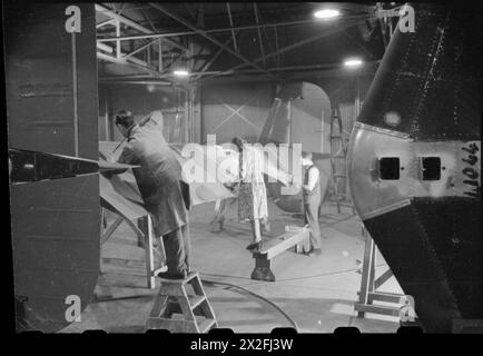 NAISSANCE D'Un BOMBARDIER : PRODUCTION D'AVIONS EN GRANDE-BRETAGNE, 1942 - hommes et femmes au travail sur la queue d'un bombardier Halifax à l'usine Handley page à Cricklewood Banque D'Images