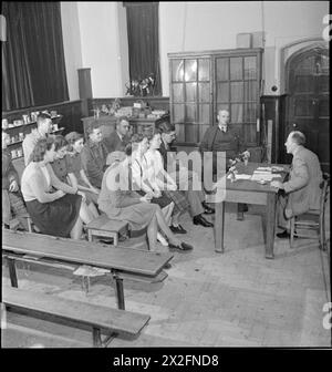 VILLAGE AUTONOME : LA VIE À HOVINGHAM, YORKSHIRE, OCTOBRE 1942 - Thomas Hugill s'adresse au club de lapins local dans la salle de classe du village à Hovingham. Les lapins sont gardés pour fournir de la viande supplémentaire pour les membres du club et les peaux sont utilisées pour les manteaux des aviateurs Banque D'Images