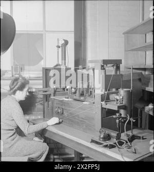 En 1944, un scientifique du National Physical Laboratory de Teddington, en Angleterre, utilise un équipement optique pour mesurer l'effet de réfraction des nuances sur un sextant afin d'assurer une mesure angulaire précise pendant les travaux scientifiques en temps de guerre. Banque D'Images