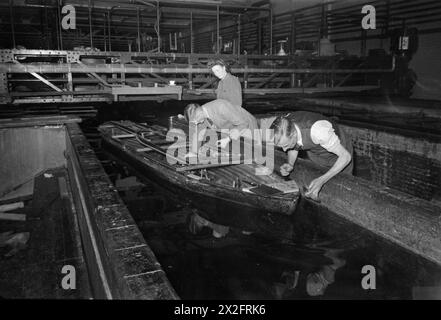 Des techniciens du laboratoire national de physique de Teddington installent un moteur d'entraînement et un engrenage de transmission sur un modèle de navire pour un essai d'autopropulsion en 1944. Banque D'Images