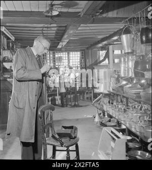 YMCA SNAPSHOTS FROM HOME : CIVILIAN PHOTOGRAPHERS AT WORK, UK, 1944 - L'Ironmonger Bernard Pinder prépare son appareil photo pour un après-midi de photographie dans sa boutique de Market Square, Salisbury, Wiltshire. Il est midi un samedi, et la boutique est fermée pour la journée, ce qui permet à M. Pinder de consacrer le reste de la journée à la photographie Banque D'Images