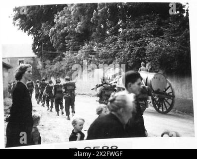 SCÈNES DANS LES RUINES DE TILLY SUR SEULLES - des villageois français se tiennent au bord de la route pour regarder l'infanterie canadienne marcher à travers le village sur leur chemin vers la ligne de front. Calgarry Highlanders à Crepon British Army, 21e groupe d'armées Banque D'Images