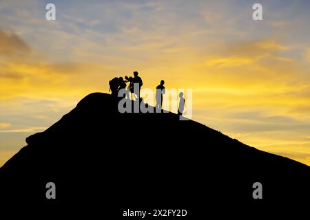 Équipe silhouette menant des recherches sur les volcans pendant le coucher de soleil pittoresque en toile de fond Banque D'Images