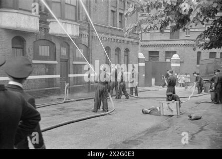 AU CENTRE DE FORMATION DE LA MARINE MARCHANDE HMS GORDON. JUIN 1941, HMS GORDON, GRAVESEND. CES HOMMES ONT SIGNÉ POUR LE SERVICE DANS LA ROYAL NAVY ET ONT ÉTÉ INVITÉS À SE PORTER VOLONTAIRES POUR LE SERVICE MARCHAND. - Exercice incendie et exercices ARP à l'établissement de formation Banque D'Images