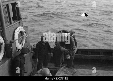 OPÉRATIONS LOFOTEN. DÉCEMBRE 1941, À BORD D'UN DES NAVIRES DE GUERRE HM PARTICIPANT À DES OPÉRATIONS DANS LES ÎLES LOFOTEN, NORVÈGE. LES QUISLINGS NORVÉGIENS ET LES ALLEMANDS SONT FAITS PRISONNIERS PENDANT LES OPÉRATIONS. - Prisonniers allemands emmenés à terre dans un drifter. Ils ont tous été soigneusement pliés à l'aveugle Banque D'Images