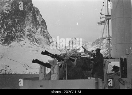 OPÉRATIONS LOFOTEN. DÉCEMBRE 1941, À BORD DE L'UN DES NAVIRES DE GUERRE PARTICIPANT AUX OPÉRATIONS DANS LES ÎLES LOFOTEN, NORVÈGE. - Les pom-poms d'un des navires HM silhouettés contre les montagnes enneigées alors qu'elle se trouve dans le fjord Kirke Banque D'Images