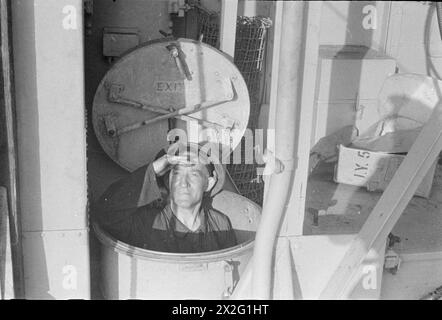 Un stoker à bord d'un navire de la Royal Navy participant au raid diurne des opérations combinées sur Dieppe le 20 août 1942 prend une pause lors d'une accalmie au combat. Banque D'Images