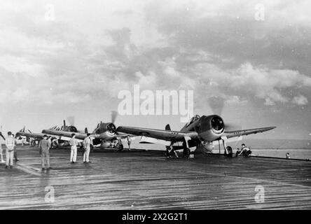 SERVIR DANS L'EST. MARS 1945, À BORD DU PORTE-AVIONS D'ESCORTE HMS EMPRESS ET DANS UNE BASE AÉRIENNE DE LA ROYAL NAVY À COLOMBO, CEYLAN. LE PERSONNEL D'ARMEMENT AÉRIEN DE LA FLOTTE SERVANT DANS L'EST. - Hellcats de la Royal Navy, équipés de chars à longue portée, sur le point d'être catapultés au large du HMS EMPRESS Banque D'Images