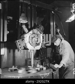 USINE SOUTERRAINE : VIE QUOTIDIENNE DANS UNE USINE SOUTERRAINE, PROBABLEMENT CARRIÈRE DE PRINTEMPS, CORSHAM, WILTSHIRE, ANGLETERRE, 1942 - Ernest Tasker travaille sur une grosse machine dans cette usine souterraine. Selon la légende originale, M. Tasker avait travaillé dans la production d'obus pendant la première Guerre mondiale Banque D'Images