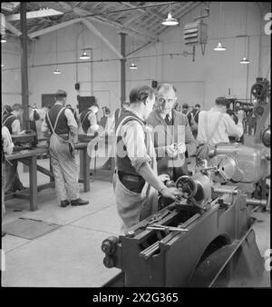 PRISON ET CAMP DE FORMATION DE WAKEFIELD : VIE QUOTIDIENNE DANS Une PRISON BRITANNIQUE, WAKEFIELD, YORKSHIRE, ANGLETERRE, 1944 - dans les travaux d'ingénierie de la prison de formation de Wakefield, les détenus sont formés à un nouveau métier dans le cadre de leur réadaptation et de leur préparation à leur retour dans la société. Au premier plan, l'un des quatre membres du personnel de la prison explique un point à l'un des prisonniers Banque D'Images