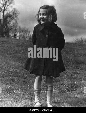 COLONY FOR ARTISTS UNDER SIX : ÉVACUÉES À DARTINGTON HALL, TOTNES, DEVON, ANGLETERRE, 1941 - Un portrait en pied de June Mancini, cinq ans évacuée de Blackfriars à Londres, debout dans un champ ensoleillé lors d'une promenade de son billet à Dartington Hall, près de Totnes dans le Devon Banque D'Images