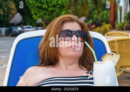 Touriste cubaine buvant un cocktail Pina colada, Santa Clara, Cuba Banque D'Images