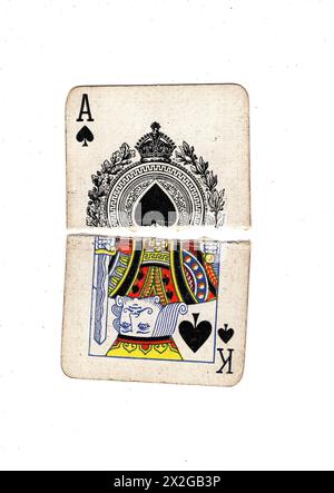 Moitiés déchirées de cartes à jouer vintage montrant un roi et as de pique sur un fond blanc. Banque D'Images