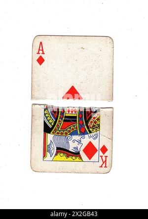 Moitiés déchirées de cartes à jouer vintage montrant un as et roi de diamants sur un fond blanc. Banque D'Images