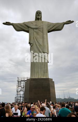 Vue rapprochée vers l'avant de la statue du Christ Rédempteur, avec les touristes à la base levant les yeux. Banque D'Images