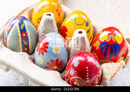 Oeufs de pâques peints à la main colorés dans une boîte à oeufs Banque D'Images