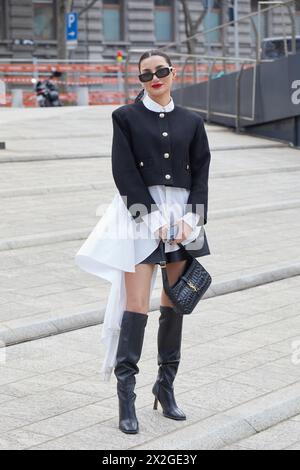 MILAN, ITALIE - 24 FÉVRIER 2024 : femme avec robe noire et blanche et sac Yves Saint Laurent avant le défilé Ermanno Scervino, Milan Fashion Wee Banque D'Images