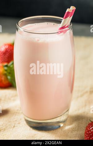 Lait de fraise rose sain dans un verre avec une paille Banque D'Images