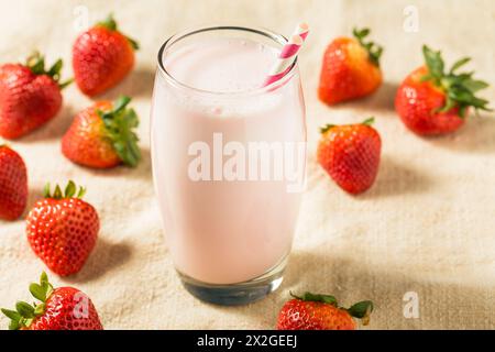 Lait de fraise rose sain dans un verre avec une paille Banque D'Images