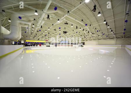 grande patinoire intérieure lumineuse, personnes, personnel de service, glace polie Banque D'Images