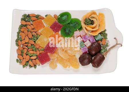 Variété de desserts sucrés dans l'assiette pour les vacances. Marmelade, fruits confits, mangue, kiwi, noix, graines, bonbons au chocolat et délice turc dans un pla Banque D'Images