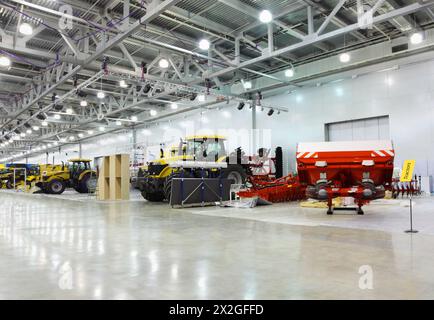 De gros tracteurs sont dans la salle à l'exposition, des machines agricoles spéciales Banque D'Images