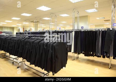 rangées de vestes et pantalons pour hommes sur cintres dans le grand magasin de lumière Banque D'Images