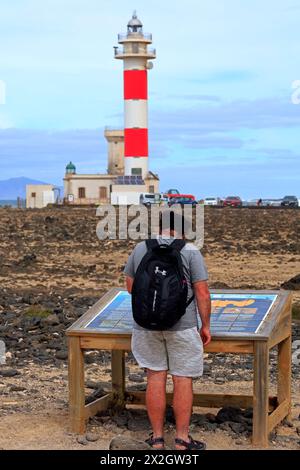 Homme au panneau d'information pour le phare de Faro Del Tostón et le musée de la pêche, El Cotillo, Fuerteventura, Îles Canaries, Espagne, Europe. Prise en février 2024 Banque D'Images