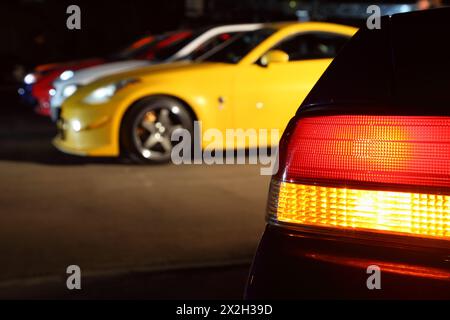 Nombre de voitures multicolores dans le parking. Focus sur le feu arrière rouge. Banque D'Images