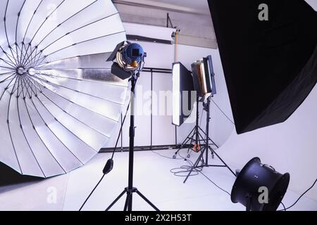 Studio photo vide avec de nombreux équipements d'éclairage modernes ; arrière-plans blancs Banque D'Images