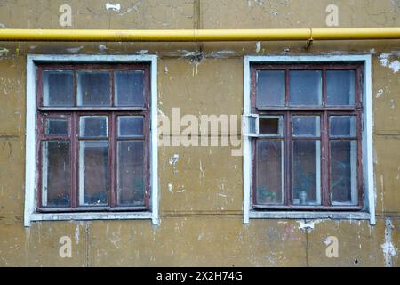 Vieux mur de pelage sale avec tuyau jaune Banque D'Images