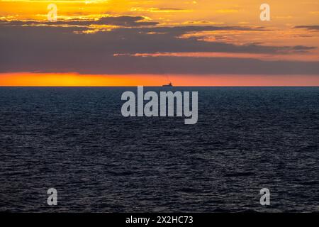 Lever du soleil tôt le matin en mer dans l'océan Atlantique, Bulk Carrier Tanker Cargo Ship sur l'horizon Banque D'Images