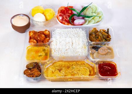 Repas Thali bengali indien mixte avec plats végétariens et non végétariens, comprenant du riz ordinaire, des plats de légumes et du curry de poisson épicé. Banque D'Images