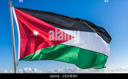 Die Fahne von Jordanien flattert im Wind, isoliert gegen blauer Himmel Banque D'Images