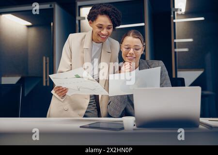 Deux femmes parmi les cadres professionnels experts discutant de documents comptables financiers travaillant ensemble Banque D'Images