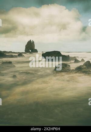 Coucher de soleil dans les tons dorés et bleus entre les rochers de la plage de Portizuelo, sur la côte asturienne, Espagne Banque D'Images