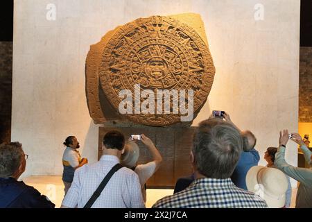 Touristes regardant la pierre aztèque du Soleil ou calendrier aztèque ; début des années 1500, sculpture aztèque Mexica, Musée national d'anthropologie, Mexico, Mexique Banque D'Images