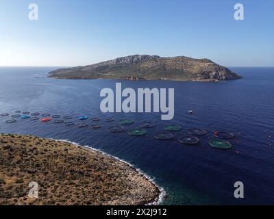 Athènes, Grèce. 19 avril 2024. Dans une vue aérienne, les cages à poissons flottent à la surface de l'eau à la ferme piscicole du groupe Kastelorizo dans le golfe Saronique. La pisciculture peut offrir une approche durable pour inverser la surexploitation des populations de poissons sauvages. Crédit : Dimitris Aspiotis/Alamy Banque D'Images