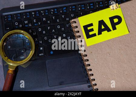 Sur un fond clair, un cahier brun, un stylo noir et des trombones et une carte jaune avec le texte Programme d'aide aux employés du PAE Banque D'Images