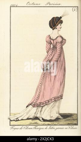 Femme en bonnet toque en velours, tunique basse en satin rose avec bordure en velours, sur une robe blanche et des chaussons. Toque de velours. Tunique de satin, garnie en velours. Planche 523 dans l'édition parisienne. Gravure sur cuivre colorée à la main tirée du Journal des Dames et des modes de Pierre de la Messengere, Francfort sur le Mein (Francfort) 1804. D’après des illustrations de Carle Vernet, Jean-François Bosio, Dominique Bosio et Philibert Louis Debucourt. Banque D'Images