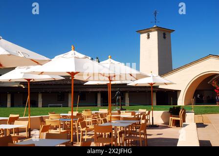 Des tables de café avec parasols sont installées à l'arrière du domaine Robert Mondavi Winery à Napa, en Californie Banque D'Images