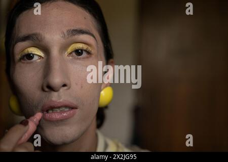 Un jeune homme transgenre (22) est dans sa chambre en train de se maquiller. Concept transgenre Banque D'Images